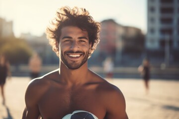 A shirtless man holding a soccer ball on a beautiful beach. Perfect for sports and beach-themed...