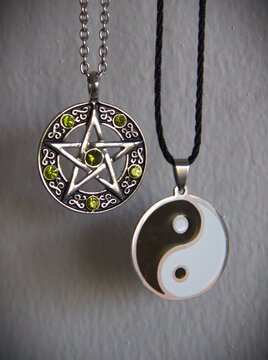 Two pendants with a pentagram and a jin-jang symbols