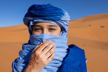 Young woman with blue turban in the desert - 738651868
