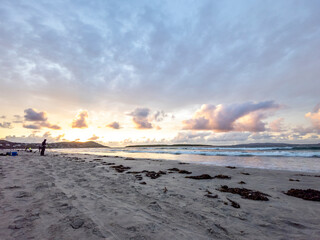 20 man are competing in a fishing competition on the beach.