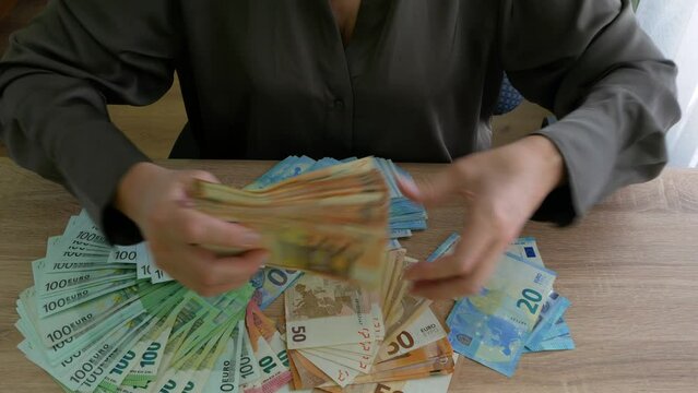Woman's Hands holding and counting big stack of euro money on wooden table. money cash, pawnshop