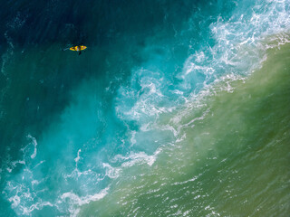 Two divers in yellow kayaks are rowing in the mouth of the Hadera River in Israel, the color of the water is spectacular and ranges from green to blue