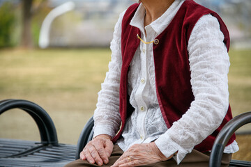 公園のベンチに座る高齢の女性