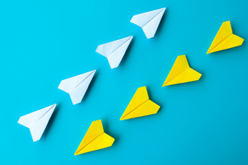 Top view of a white and yellow paper airplanes origami flying at different direction