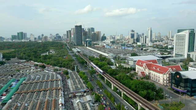 Aerial view of BTS Skytrain near Chatuchak Market and skyscrapers city skyline in Bangkok, Thailand.