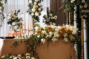 Fototapeta na wymiar Festive wedding table for the newlyweds, decorated with fresh flowers