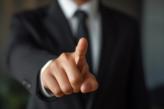Businessman pointing at something invisible with focus on finger. Touchscreen or virtual screen for technology or business concept.