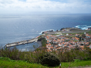 View from above to Vila do Corvo with Flores Island in the horizon across the canal