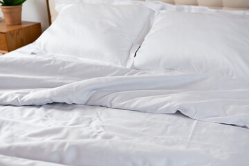 Fototapeta na wymiar White cotton bedclothes on bed morning messy concept