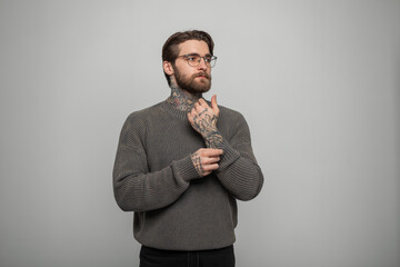 Stylish handsome successful hipster man with a beard and hairstyle with fashionable glasses in a...