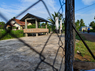 a building at the edge of the volleyball court on the side of the road with a cloudy blue sky screen