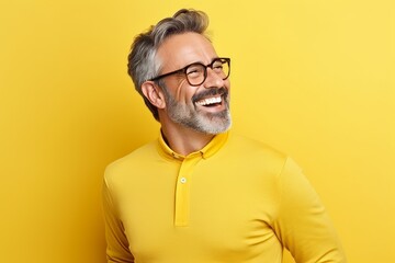 Portrait of a happy senior man in eyeglasses over yellow background