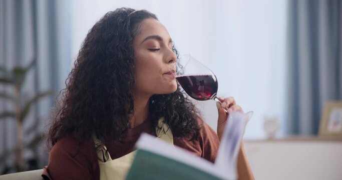Woman, reading and book with red wine on sofa, relax and drinking alcohol with novel on weekend. Lady, happiness and enjoy champagne on holiday for wellness, peace and cozy with literature in house