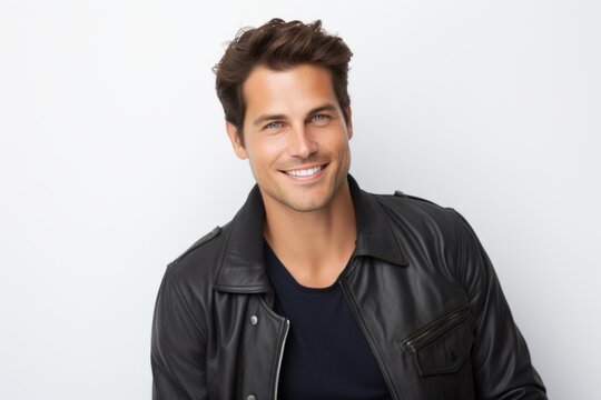 Portrait of handsome young man in black leather jacket on white background