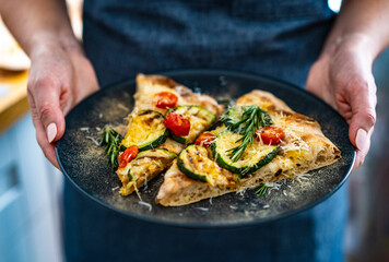 Pinsa Romana with mozzarella cheese and grilled zucchini and rosemary on wooden table