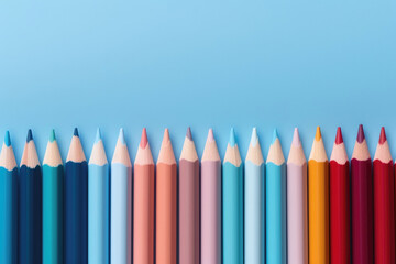 Vibrant colored pencils in a gradient array against a calming blue backdrop, ideal for artists, educators, and creative projects. Showcases a spectrum of shades from cool to warm tones. - Powered by Adobe
