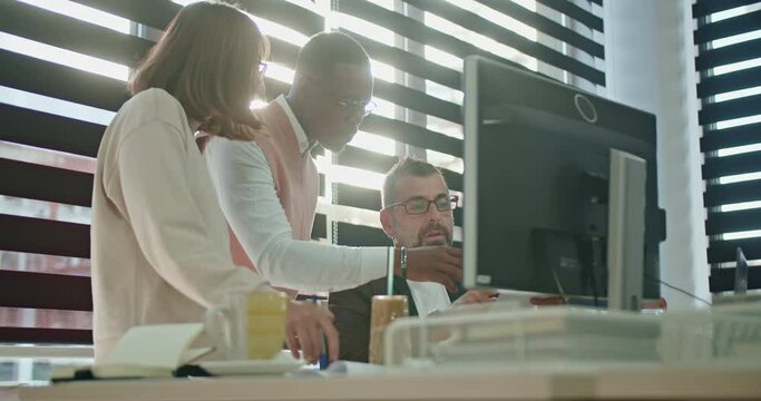 Team members of various ages infuse energy into the sunlit office space, fostering a dynamic environment where diverse perspectives converge, fueling innovation during project collaboration.