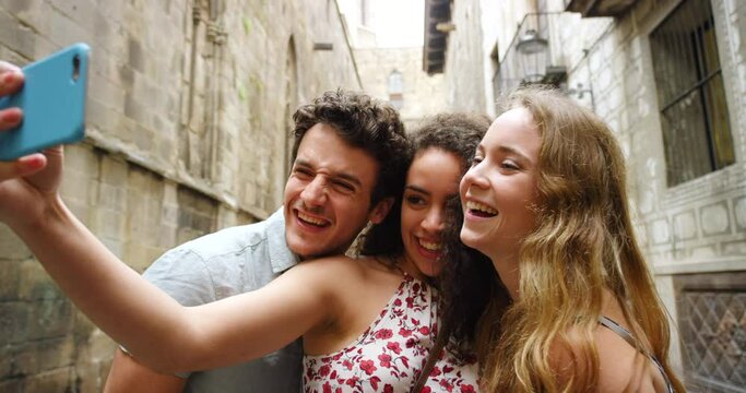 Friends, women and selfie in street, kiss and funny face with smile, laugh or excited for live stream. Group, gen z girl and people with photography, post or choice on social media in Barcelona