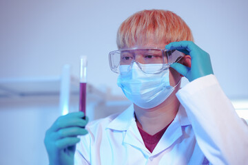 Asian middle-aged male scientist conducts research in a laboratory, surrounded by petri dishes and...