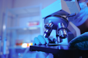 Asian middle-aged male scientist conducts research in a laboratory, surrounded by petri dishes and...