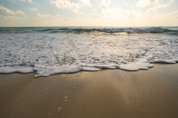 Fototapeta na wymiar Sea beach wave splash on sand beach sunrise relax summer vacation