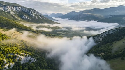Fototapeta na wymiar Aerial view of a valley with fog in early morning mist among mountains in Psaka, Epirus, Greece.
