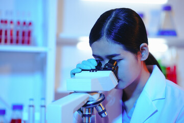Asian female scientist passionately conducts experiments in a laboratory, surrounded by petri...