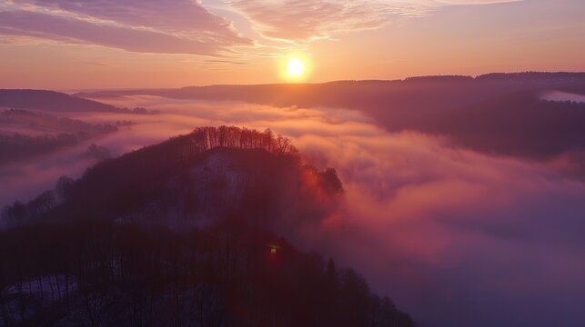 Drone view of sun rising over fog shrouded welzheim forest