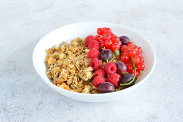 healthy granola with fresh berries in white bowl close up 