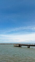 Fototapeta na wymiar old bridge over the sea with bright sky color