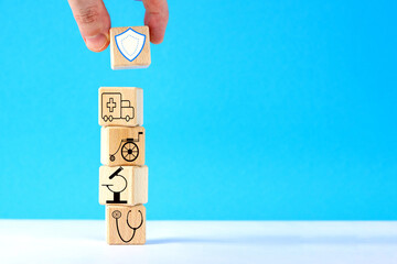 Hand puts wooden cube  with healthcare medical icons.