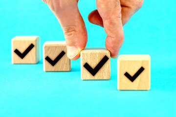  Check mark on wooden blocks, blue background with copy space.