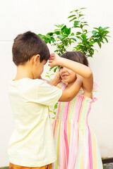 Obraz premium Behavior among siblings. Caucasian brother and sister children playing fun with each other. Vertical.