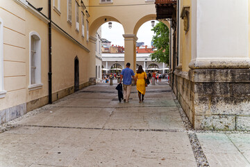 Couple strolling and holding hands at the old town of City of Ljubljana at hiking trail to castle...