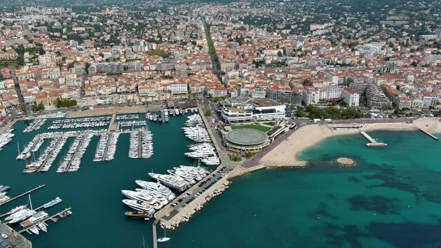 High angle altitude helicopter view aerial shot of Cannes City located on French Riviera and host of annual Film Festival ft. Cannes port panoramic view around rich and famous Cote d'Azur in France 4K