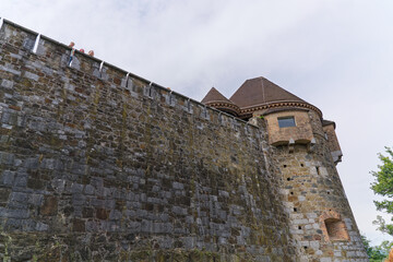 Looking up stone wall and tower with loophole of Castle of Ljubljana on a cloudy summer day. Photo...