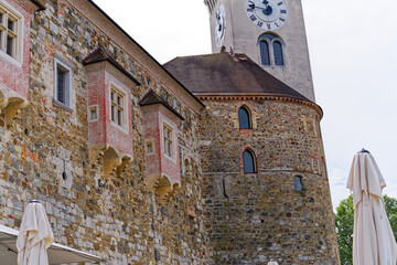 Looking up stone wall and tower with loophole of Castle of Ljubljana on a cloudy summer day. Photo...