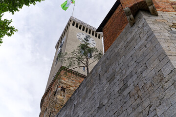 Looking up stone wall and tower with loophole of Castle of Ljubljana on a cloudy summer day. Photo...