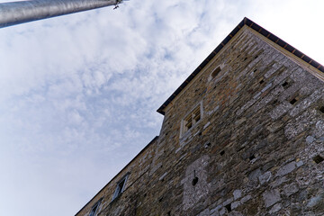 Looking up stone wall and tower with loophole of Castle of Ljubljana on a cloudy summer day. Photo...