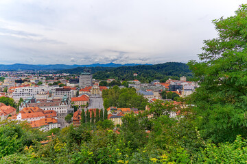 Aerial view of City of Ljubljana seen from Sance castle hill with mountain panorama in the background on a cloudy summer day. Photo taken August 9th, 2023, Ljubljana, Slovenia.