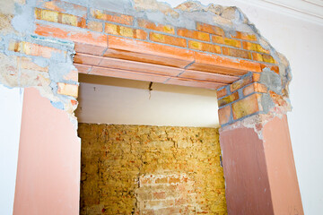 New reinforced brick lintel useful for creating a new door, or a new window, in an old stone and brick wall in a construction site - obrazy, fototapety, plakaty