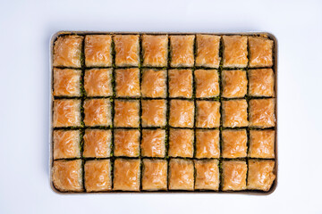 Top view of pistachio baklava on a tray isolated on white background.