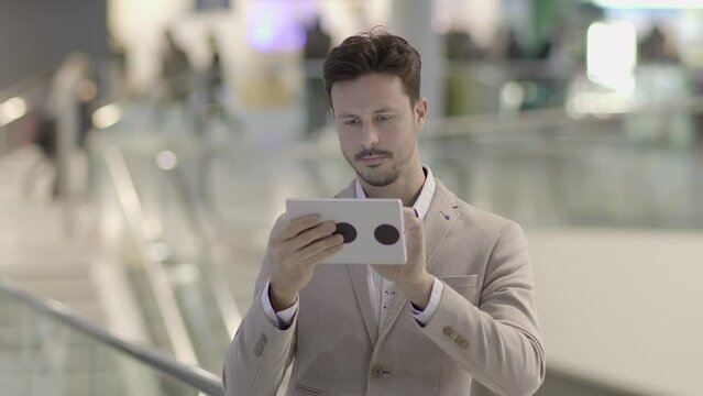 Portrait of Young Successful Man Using Tablet Screen on Business Travel Trip