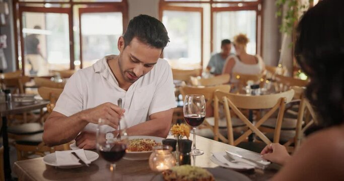 Man, eating and talking with food in restaurant at lunch with woman on date at table with fine dining. Happy, person and relax in conversation with woman and hungry for pasta on plate and laughing
