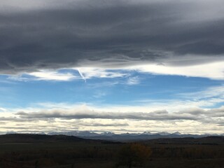 The rolling prairie of Longview Alberta topped with the grey solitude of a Chinook cloud formation. 
