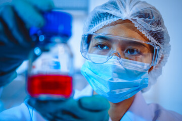 Female scientist diligently conducts virus blood lab tests, contributing to critical research and...