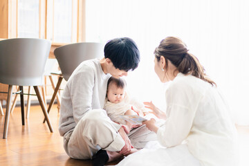 Fototapeta premium 赤ちゃんに絵本の読み聞かせをするファミリー