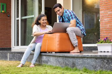 Young couple using laptop while sitting together at home