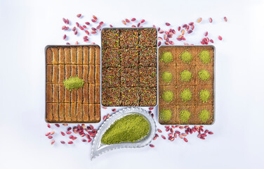 Top view of shredded phyllo dough dessert species with pistachio on trays isolated on white background. Local name is kadayıf which is a traditional Turkish cuisine dessert with pistachio and sherbet.