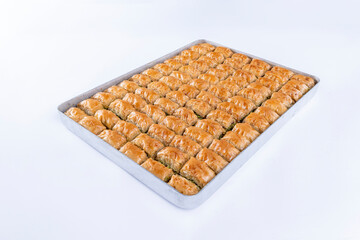 Top view of pistachio baklava on a tray isolated on white background.